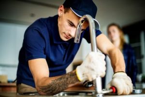 Plumber fixing kitchen sink